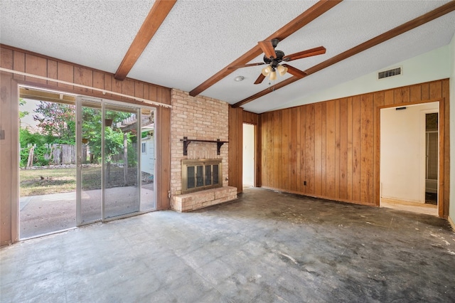 11702 Shoshone Dr, Austin, TX 78759 - unfurnished living room with wooden walls, a textured ceiling, a ceiling fan, a fireplace, and concrete floors