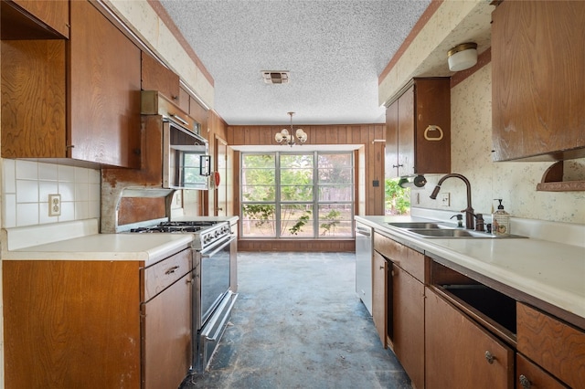11702 Shoshone Dr, Austin, TX 78759 - kitchen featuring stainless steel appliances, a textured ceiling, a chandelier, light countertops, and brown cabinetry