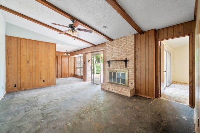 11702 Shoshone Dr, Austin, TX 78759 - unfurnished living room featuring wooden walls, a fireplace, a ceiling fan, a textured ceiling, and concrete flooring