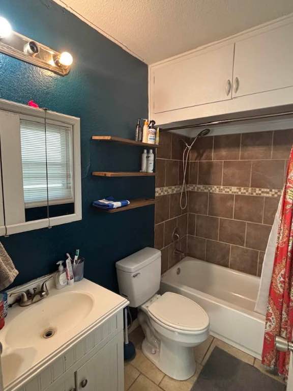 936 Cheatham St, San Marcos, TX 78666 - full bath featuring tile patterned flooring, vanity, shower / bath combo, and a textured ceiling