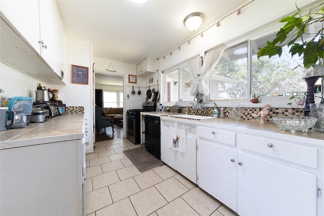 936 Cheatham St, San Marcos, TX 78666 - kitchen with stainless steel gas stove, white cabinets, light countertops, black dishwasher, and light tile patterned floors