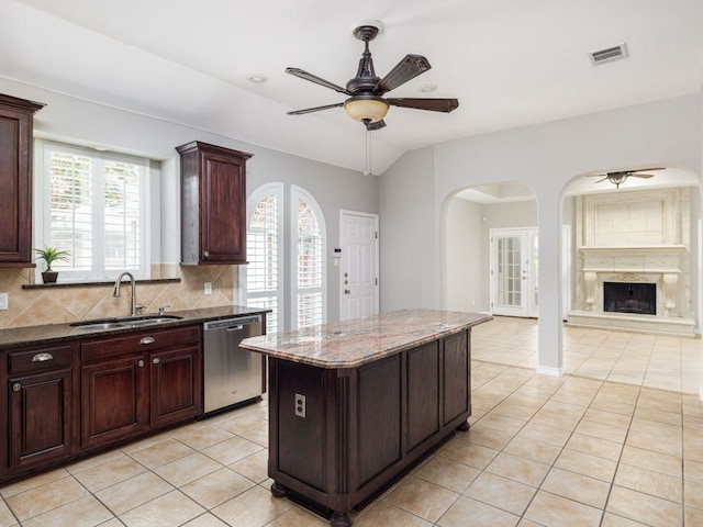17029 Ennis Trl, Austin, TX 78717 - kitchen featuring stainless steel dishwasher, a ceiling fan, light tile patterned floors, arched walkways, and tasteful backsplash