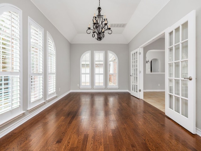 17029 Ennis Trl, Austin, TX 78717 - unfurnished dining area featuring a chandelier, wood finished floors, arched walkways, french doors, and lofted ceiling