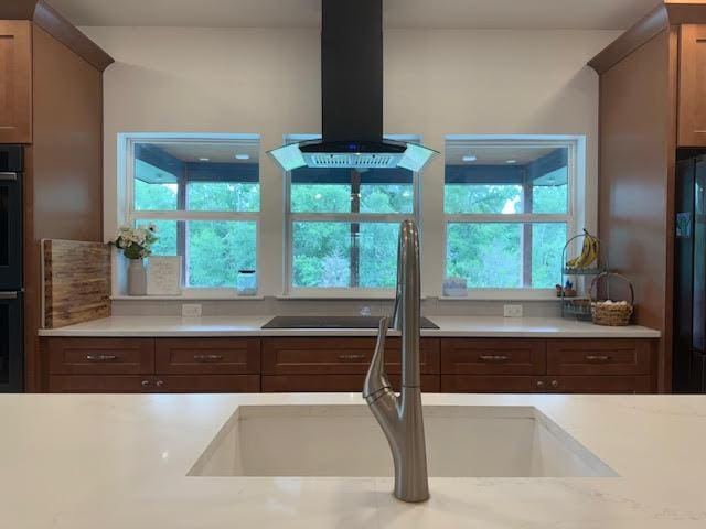 305 Goertz Dr, Red Rock, TX 78662 - kitchen with wall chimney exhaust hood, light countertops, and black appliances