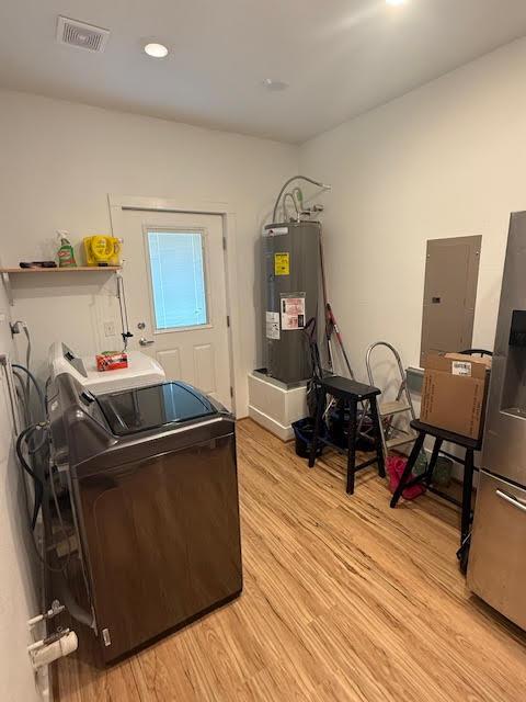 305 Goertz Dr, Red Rock, TX 78662 - misc room with electric water heater, washing machine and clothes dryer, light wood-style floors, electric panel, and recessed lighting