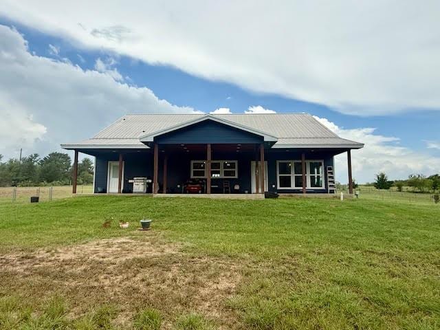 305 Goertz Dr, Red Rock, TX 78662 - rear view of house featuring a lawn and a metal roof
