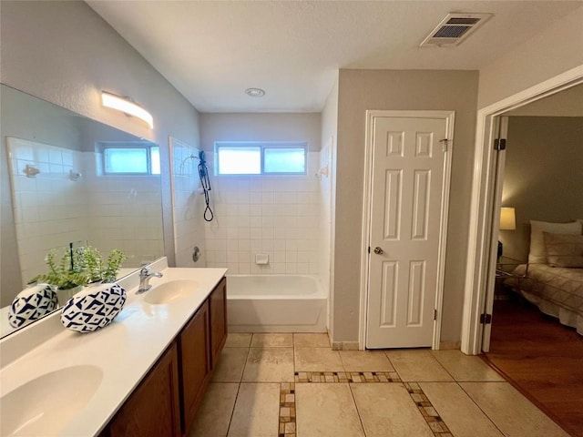 612 Thrush Dr, Leander, TX 78641 - ensuite bathroom featuring bathtub / shower combination, double vanity, and tile patterned flooring