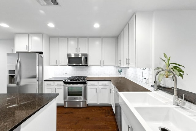 1612 Westmoor Dr, Austin, TX 78723 - kitchen featuring stainless steel appliances, dark wood finished floors, white cabinetry, recessed lighting, and decorative backsplash
