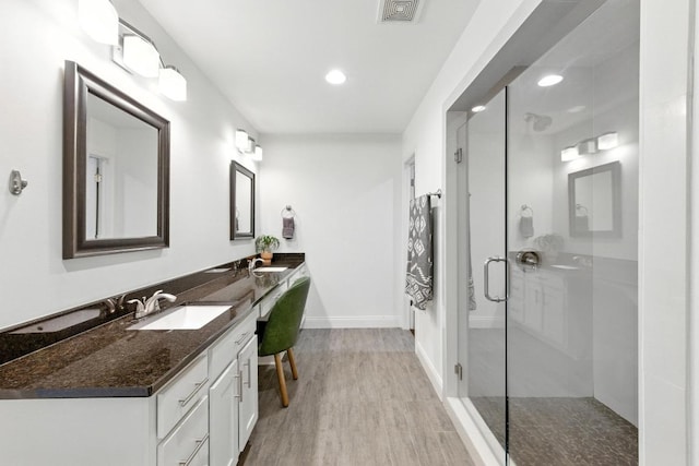 1612 Westmoor Dr, Austin, TX 78723 - full bathroom with double vanity, wood finished floors, a stall shower, and recessed lighting