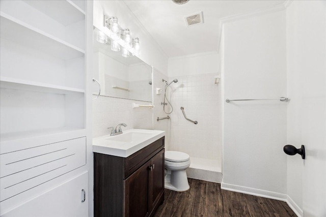 8516 Rockwood Ln, Austin, TX 78757 - bathroom with a tile shower, vanity, wood finished floors, and tasteful backsplash