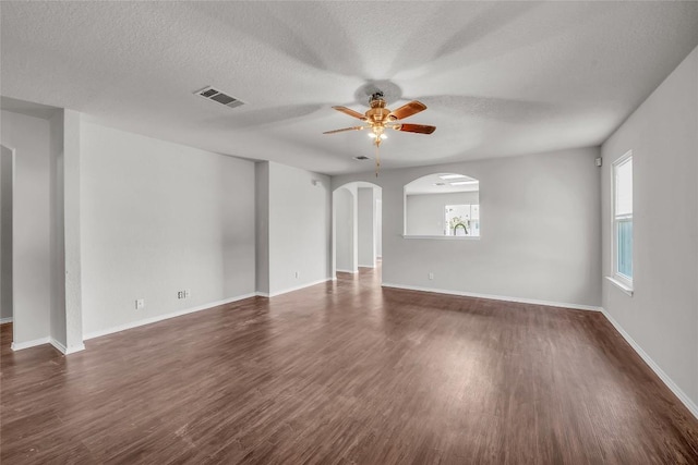 100 Grant Cv, Hutto, TX 78634 - spare room with ceiling fan, dark wood finished floors, a textured ceiling, and arched walkways