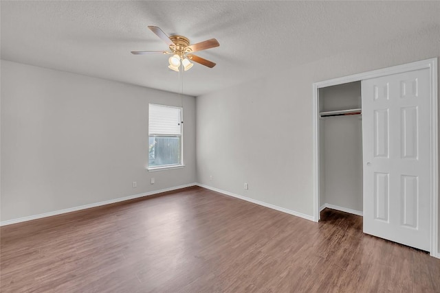 100 Grant Cv, Hutto, TX 78634 - unfurnished bedroom featuring wood finished floors, a textured ceiling, a closet, and a ceiling fan