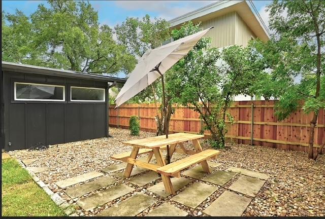 4508 Chiappero Trl, Austin, TX 78731 - fenced backyard featuring a patio, an outbuilding, and outdoor dining space
