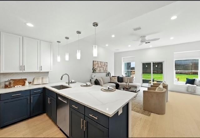 4508 Chiappero Trl, Austin, TX 78731 - kitchen with dishwasher, open floor plan, a peninsula, light wood finished floors, and white cabinetry