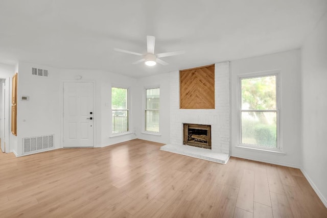 10616 Mellow Mdws Unit 17A, Austin, TX 78750 - unfurnished living room featuring a ceiling fan, healthy amount of natural light, light wood-style flooring, and a fireplace