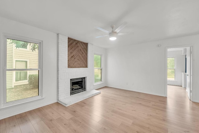 10616 Mellow Mdws Unit 17A, Austin, TX 78750 - unfurnished living room featuring a ceiling fan, a fireplace, and light wood-style flooring
