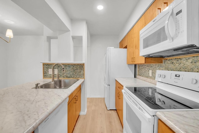 10616 Mellow Mdws Unit 17A, Austin, TX 78750 - kitchen with white appliances, light wood-type flooring, backsplash, brown cabinets, and light stone countertops