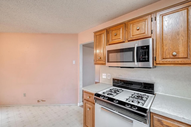 4901 Transit Cir, Austin, TX 78727 - kitchen featuring gas range gas stove, stainless steel microwave, light countertops, tile patterned floors, and a textured ceiling