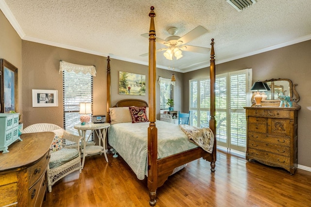 3508 Wendel Cv Unit H16, Austin, TX 78731 - bedroom with wood finished floors, a textured ceiling, ornamental molding, and a ceiling fan