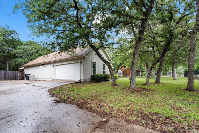 230 Cedar Hills Dr, Elgin, TX 78621 - view of home's exterior featuring stucco siding, driveway, and a garage
