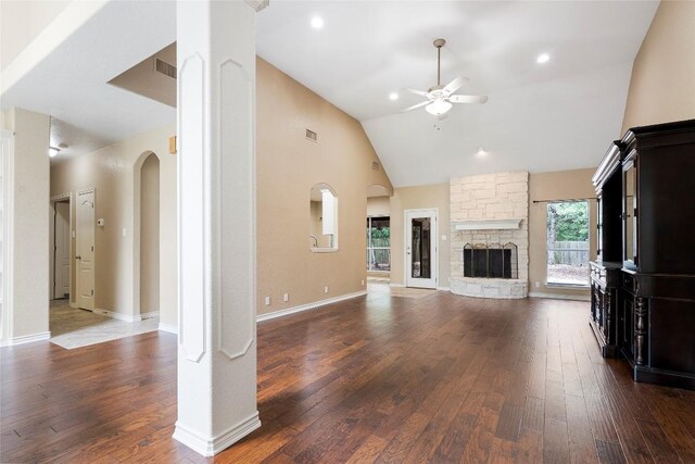 230 Cedar Hills Dr, Elgin, TX 78621 - unfurnished living room featuring a ceiling fan, dark wood-style floors, high vaulted ceiling, a stone fireplace, and arched walkways