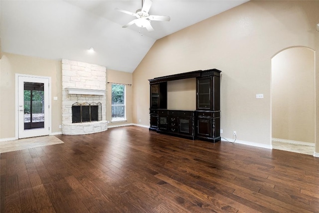 230 Cedar Hills Dr, Elgin, TX 78621 - unfurnished living room featuring ceiling fan, hardwood / wood-style flooring, arched walkways, high vaulted ceiling, and a fireplace