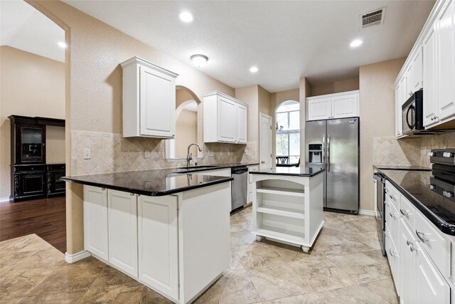 230 Cedar Hills Dr, Elgin, TX 78621 - kitchen with stainless steel appliances, open shelves, dark countertops, decorative backsplash, and a kitchen island