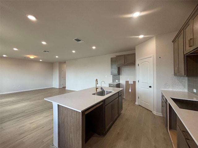 627 Palo Brea Loop, Hutto, TX 78634 - kitchen with light wood finished floors, tasteful backsplash, recessed lighting, a center island with sink, and light countertops