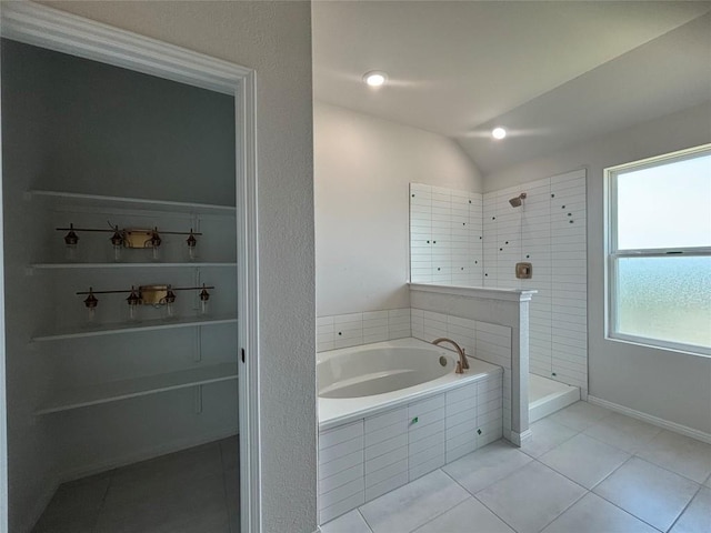 627 Palo Brea Loop, Hutto, TX 78634 - bathroom featuring a bath, tile patterned flooring, tiled shower, and vaulted ceiling