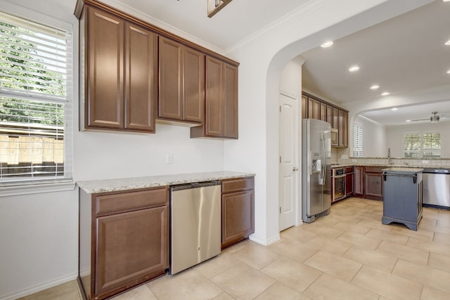 1209 Salem Park Ct, Austin, TX 78745 - kitchen with stainless steel appliances, crown molding, arched walkways, recessed lighting, and a peninsula