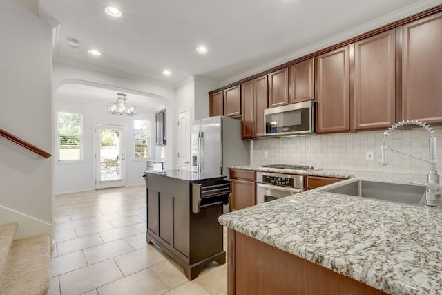 1209 Salem Park Ct, Austin, TX 78745 - kitchen with stainless steel appliances, arched walkways, crown molding, backsplash, and light tile patterned flooring
