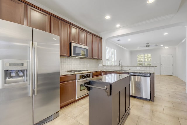 1209 Salem Park Ct, Austin, TX 78745 - kitchen with stainless steel appliances, crown molding, a peninsula, decorative backsplash, and recessed lighting