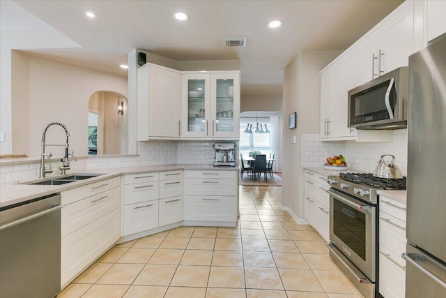13412 Snow Fall Dr, Austin, TX 78727 - kitchen featuring stainless steel appliances, backsplash, light countertops, recessed lighting, and white cabinetry