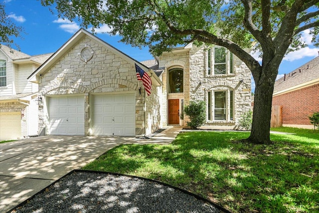 13412 Snow Fall Dr, Austin, TX 78727 - view of front of property with stone siding, an attached garage, concrete driveway, and a front lawn