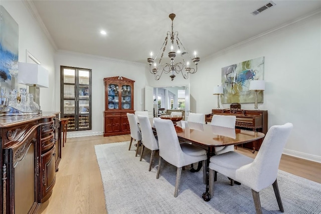 1307 Osprey Ridge Loop, Lago Vista, TX 78645 - dining room with a chandelier, light wood-style floors, and crown molding
