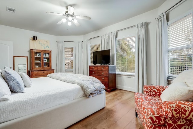 1307 Osprey Ridge Loop, Lago Vista, TX 78645 - bedroom featuring light wood-type flooring, multiple windows, and a ceiling fan