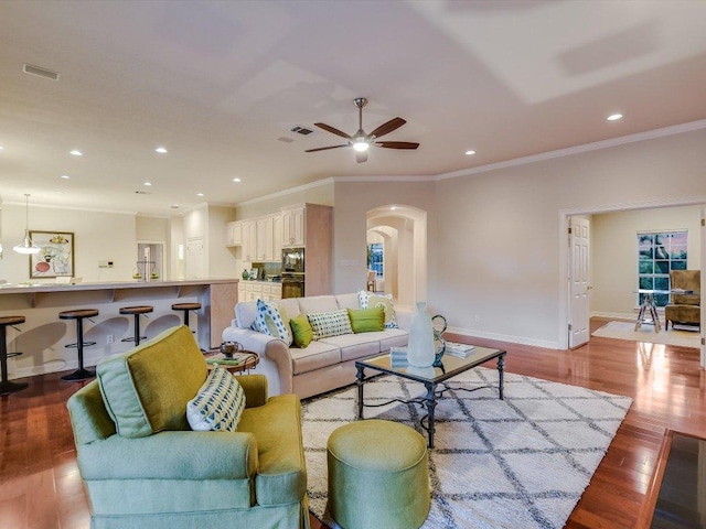 1624 Cabinwood Cv, Austin, TX 78746 - living area featuring arched walkways, ornamental molding, ceiling fan, wood finished floors, and recessed lighting