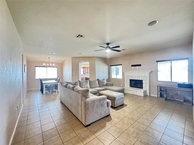 219 Memory Ln, Harker Heights, TX 76548 - living area with light tile patterned floors, a chandelier, a stone fireplace, and healthy amount of natural light