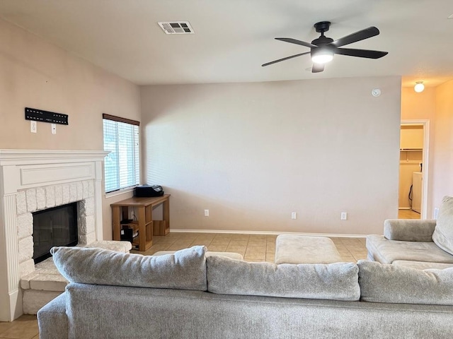 219 Memory Ln, Harker Heights, TX 76548 - living area featuring light tile patterned floors, ceiling fan, washer / dryer, and a fireplace