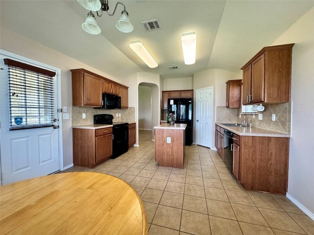 219 Memory Ln, Harker Heights, TX 76548 - kitchen with black appliances, arched walkways, tasteful backsplash, a center island, and light tile patterned floors
