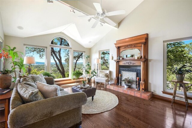 21013 Fawn Ridge Dr, Lago Vista, TX 78645 - living area featuring a tiled fireplace, wood finished floors, ceiling fan, and high vaulted ceiling