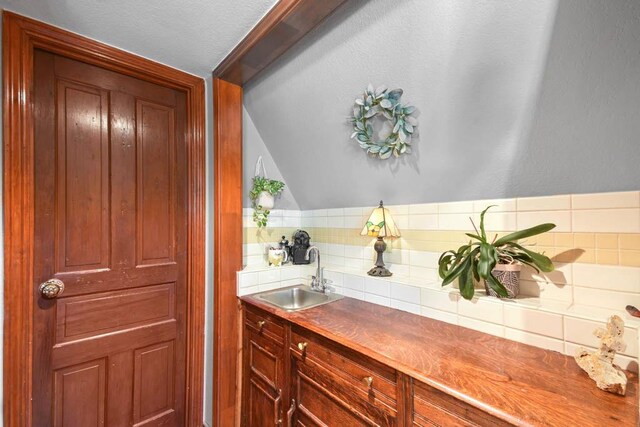 21013 Fawn Ridge Dr, Lago Vista, TX 78645 - interior space featuring decorative backsplash, vaulted ceiling, and a textured ceiling