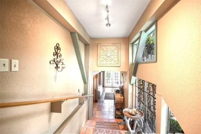 21013 Fawn Ridge Dr, Lago Vista, TX 78645 - hallway with a textured wall, light tile patterned floors, and track lighting