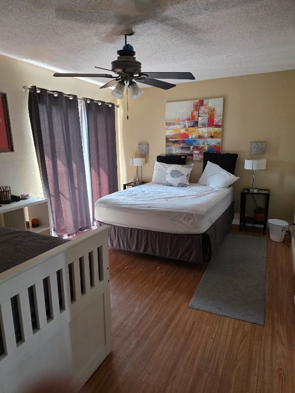 2124 Burton Dr Unit 208, Austin, TX 78741 - bedroom featuring wood finished floors, a textured ceiling, and a ceiling fan