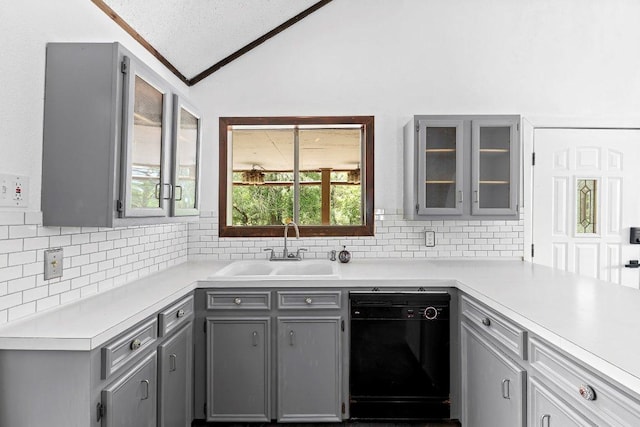 130 Anderson Ln, Red Rock, TX 78662 - kitchen with gray cabinets, vaulted ceiling, black dishwasher, tasteful backsplash, and light countertops