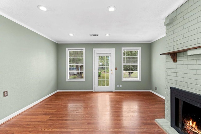 130 Anderson Ln, Red Rock, TX 78662 - unfurnished living room featuring a brick fireplace, ornamental molding, wood finished floors, and recessed lighting