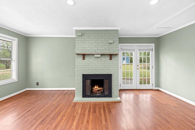 130 Anderson Ln, Red Rock, TX 78662 - unfurnished living room featuring plenty of natural light, wood finished floors, crown molding, a fireplace, and attic access
