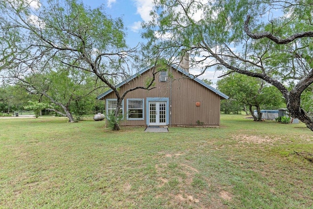 130 Anderson Ln, Red Rock, TX 78662 - rear view of house with french doors, a yard, and a chimney