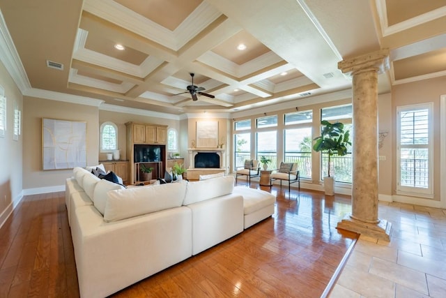 5120 Mansfield View Ct, Austin, TX 78732 - living area featuring decorative columns, healthy amount of natural light, a fireplace with raised hearth, crown molding, and beam ceiling