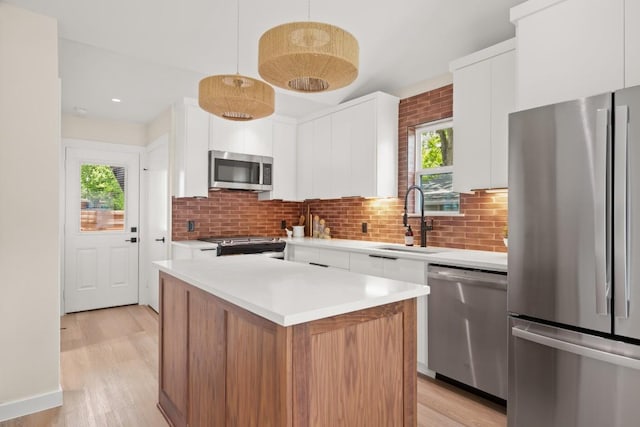3704 Munson St Unit 1, Austin, TX 78721 - kitchen featuring stainless steel appliances, white cabinetry, light wood-style flooring, and tasteful backsplash